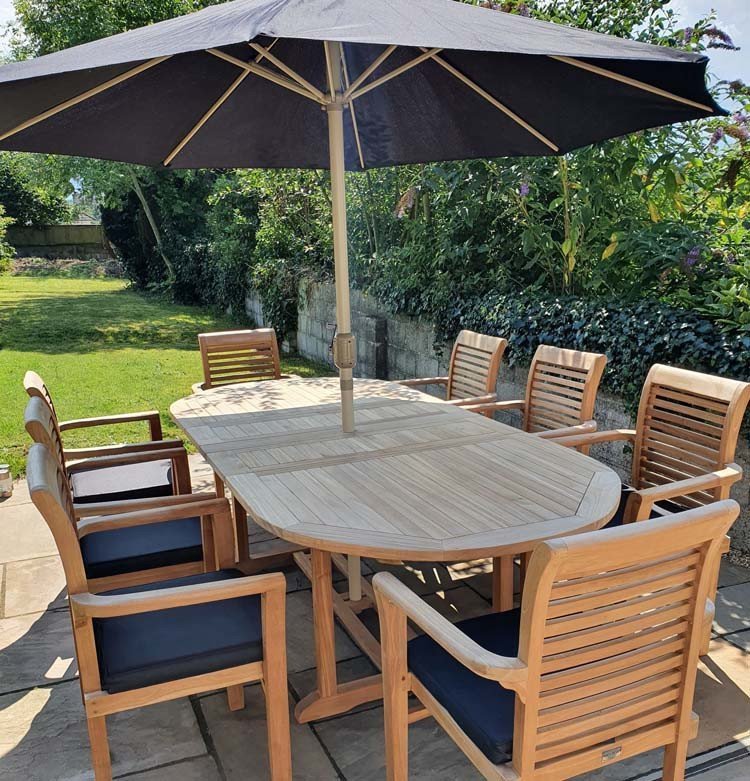 Double extendable table 1.8m to 2.4m, 8 x teak stacking chairs, free 3m parasol and cushions